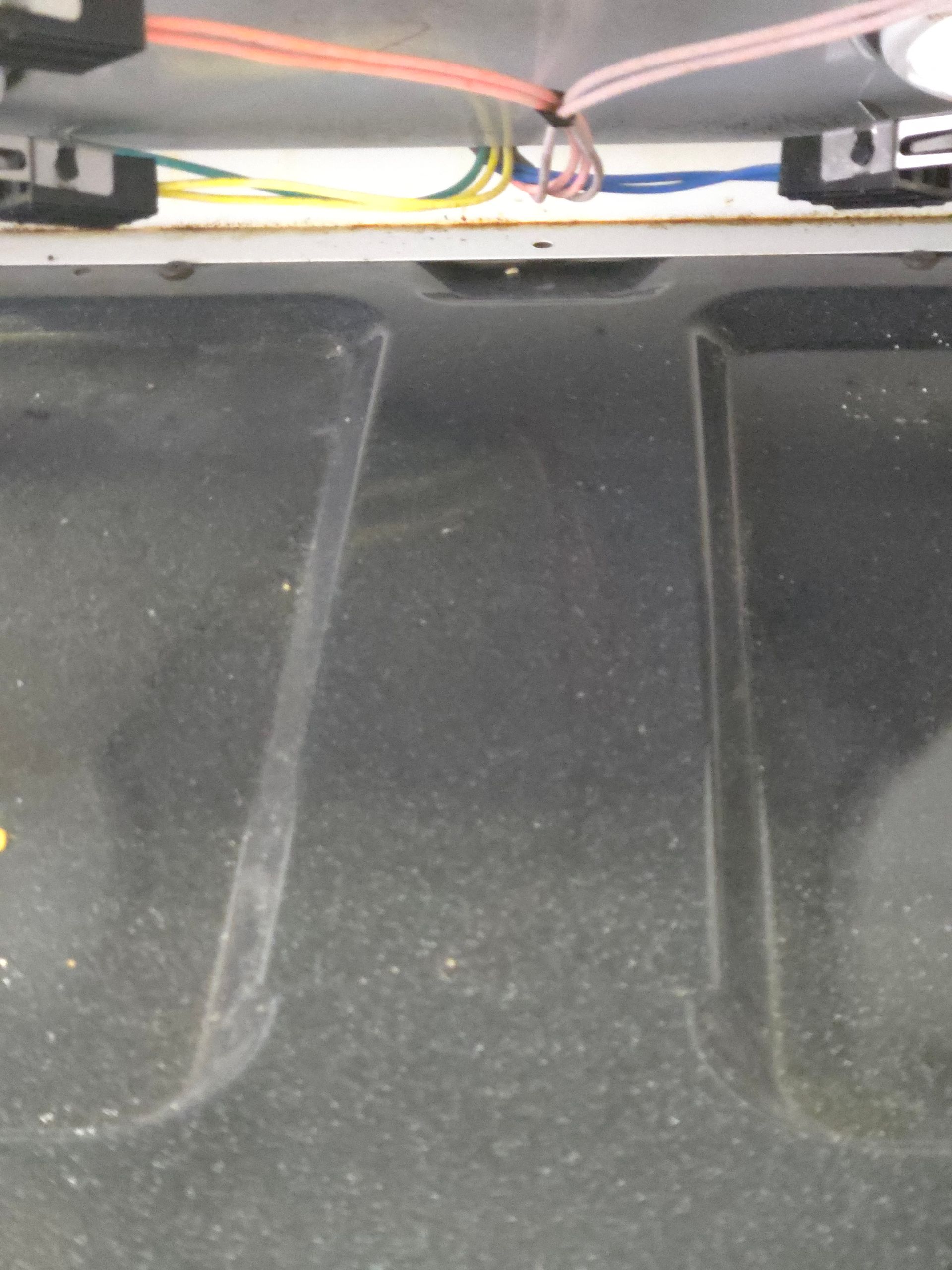 Close-up view inside a dirty oven, with the oven floor and wires visible at the top.