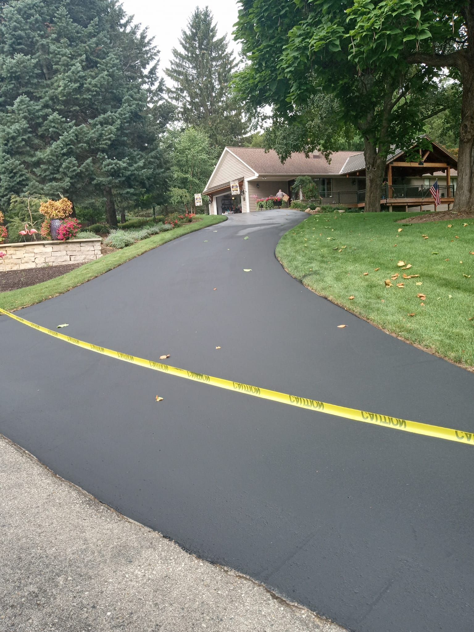 A driveway leading to a house with trees on both sides.