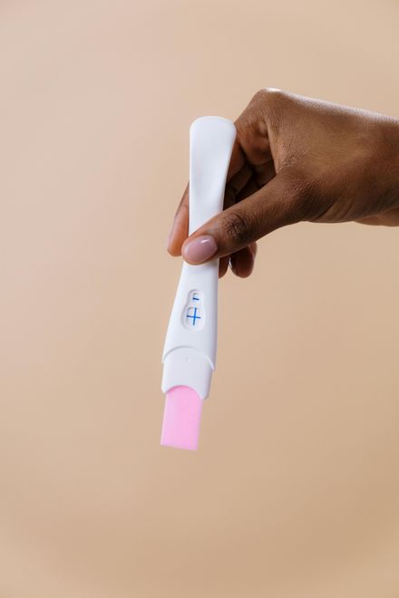 A person is holding a pregnancy test in their hand.