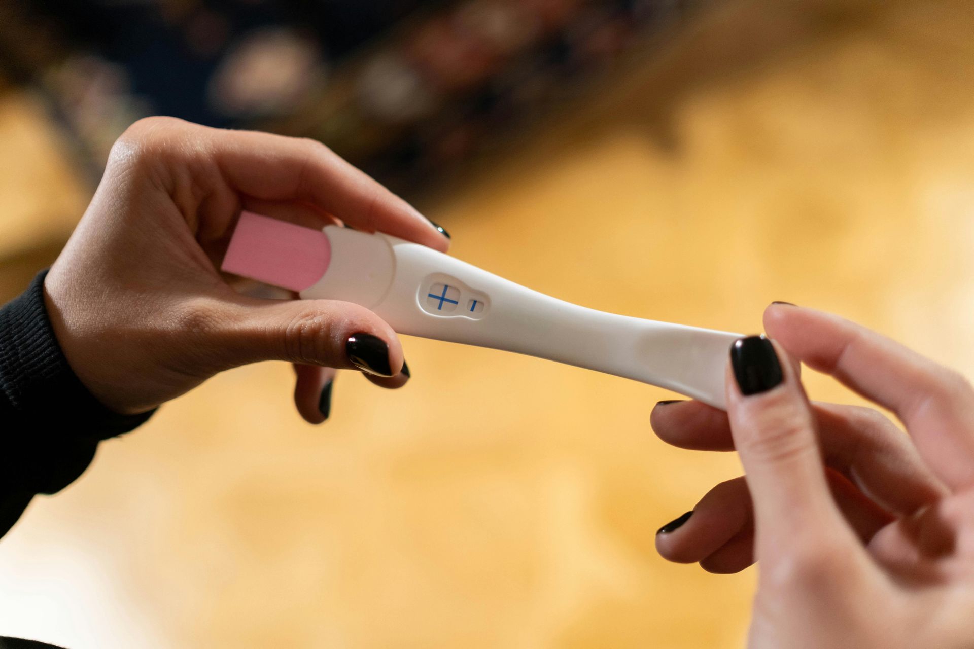 A woman is holding a pregnancy test in her hands.