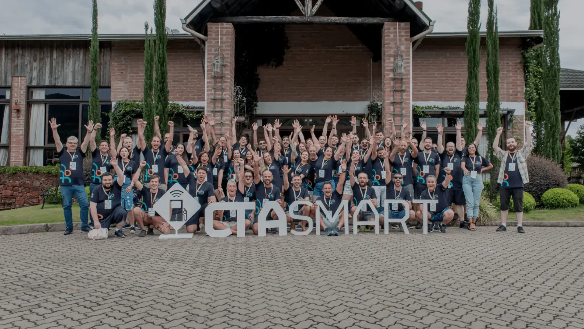 Um grande grupo de pessoas está posando para uma foto em frente a um prédio.