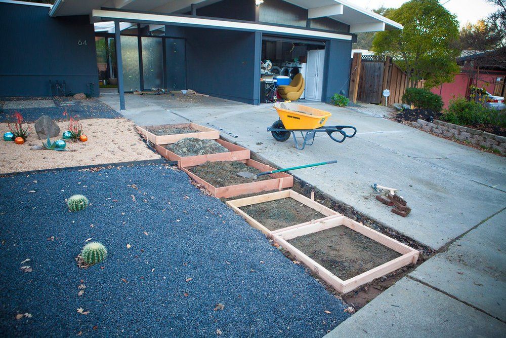 A yellow wheelbarrow is parked in front of a house