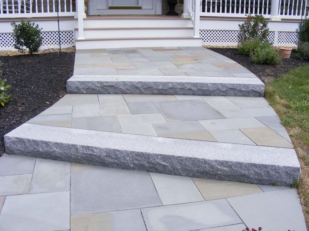 A stone walkway with steps leading up to a porch