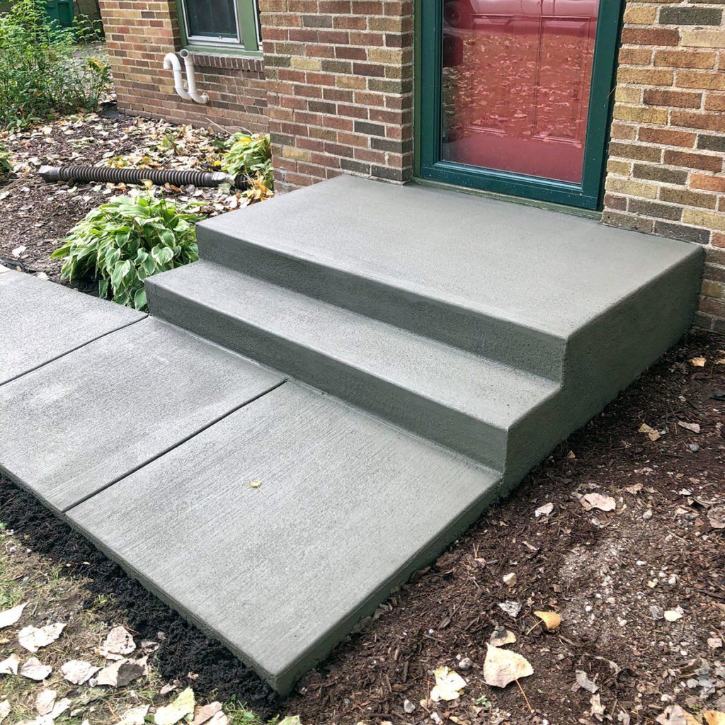 A set of concrete steps leading up to a brick building.