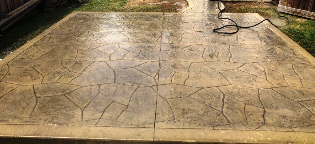 A concrete patio with a hose attached to it.