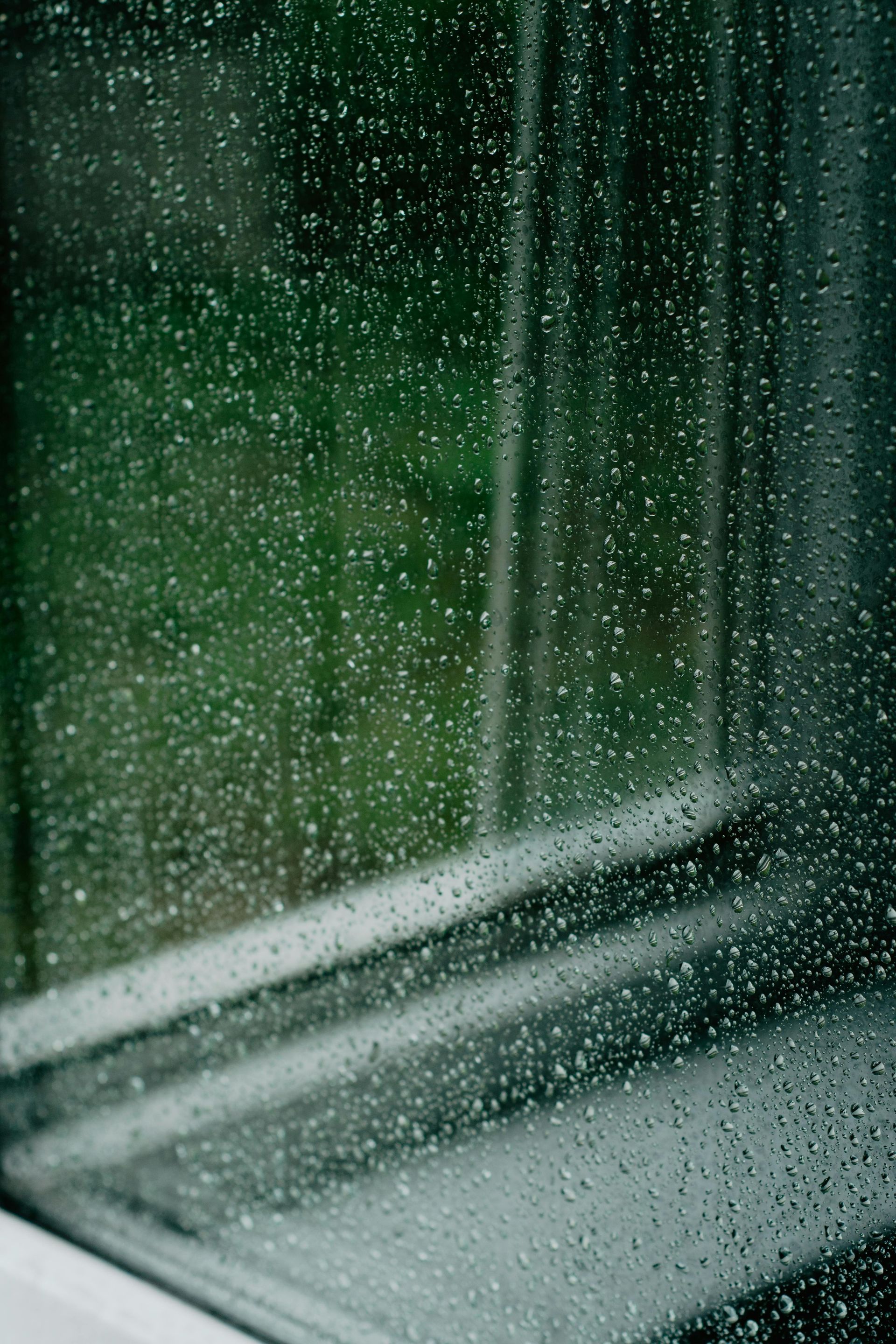 A close up of a window with rain drops on it.