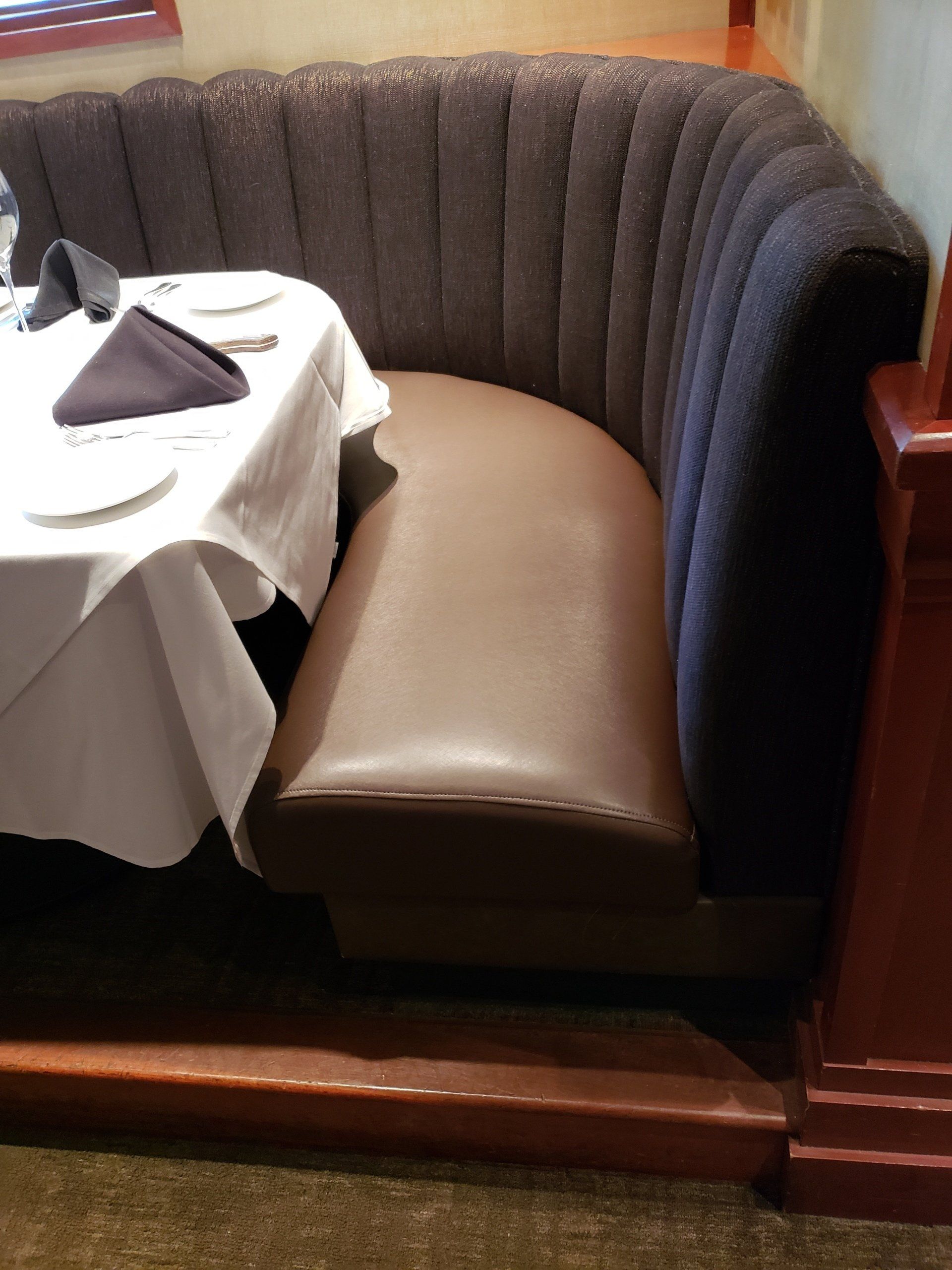 A restaurant booth with a table and napkin on it