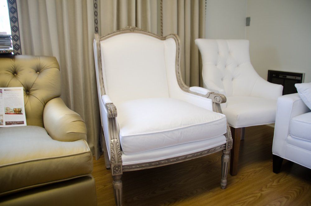 Two white chairs are sitting next to each other in a living room.