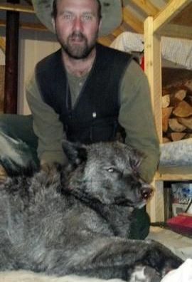 A man in a hat is laying next to a dog