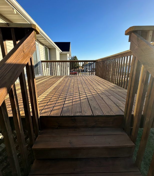 A person is painting a wooden railing with a brush.