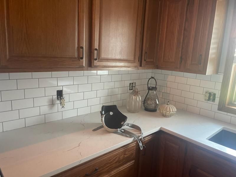 A man is using a drill to install cabinets in a kitchen