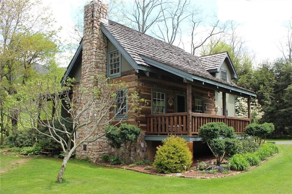 A log cabin in the middle of a lush green field