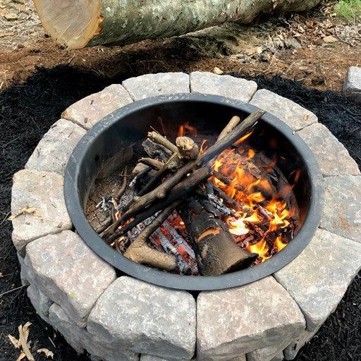 A fire pit with a log in the background