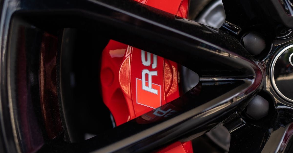 A close up of a red brake caliper on a car wheel. | Griffin Automotive