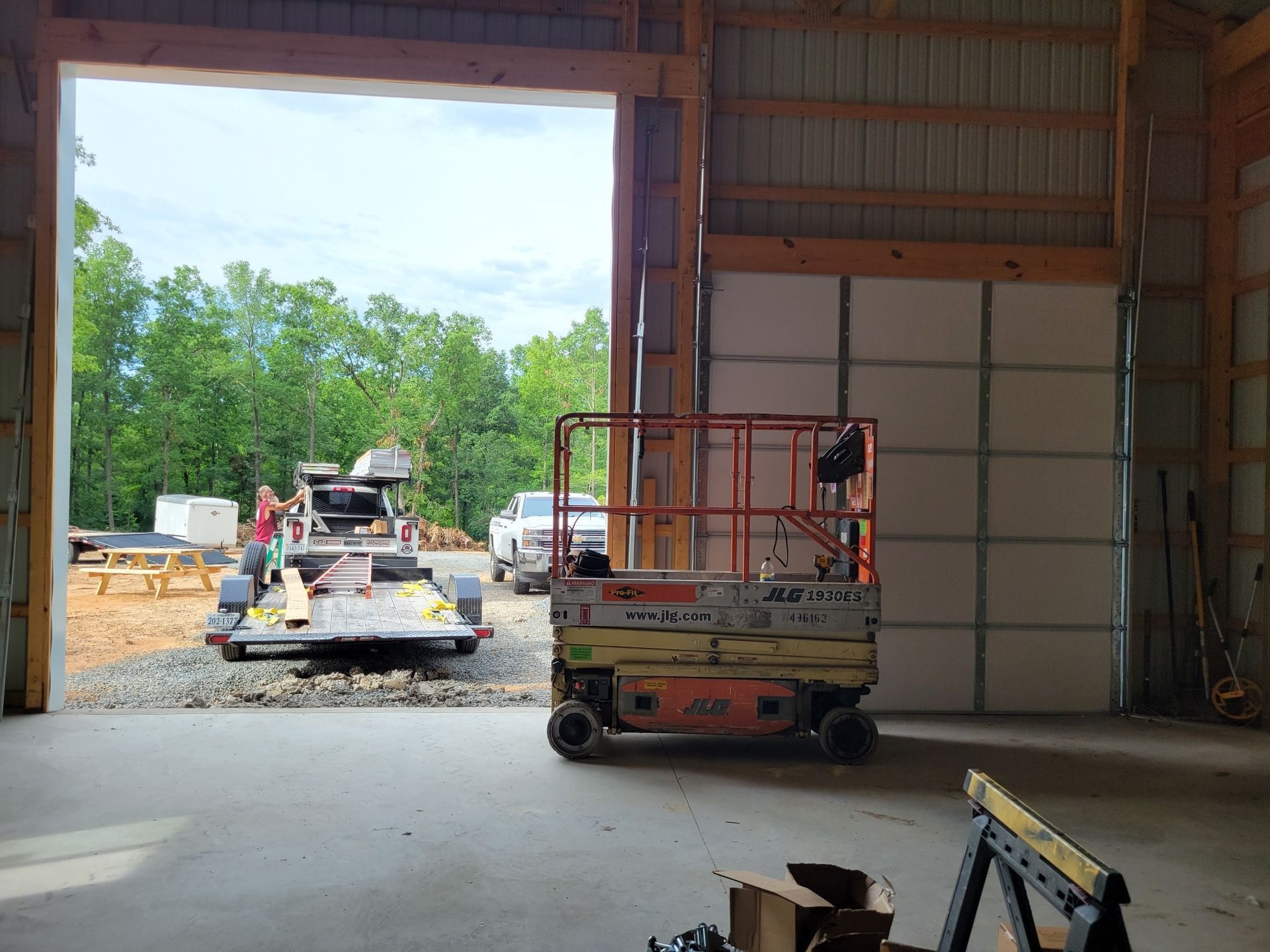 A jlg scissor lift is parked in a garage with the door open.