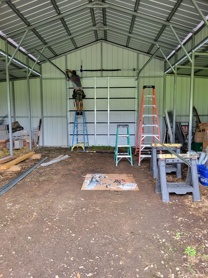 A man is standing on a ladder in a metal building.