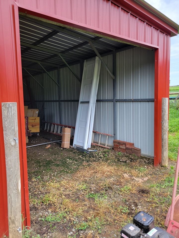 A red barn with a ladder and boxes inside of it.
