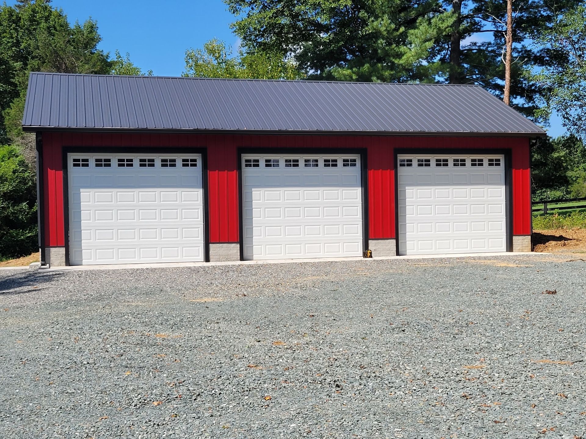 A red garage with three white garage doors