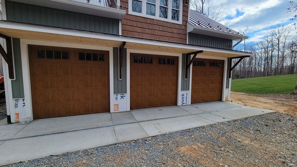 There are three garage doors on the side of a house.