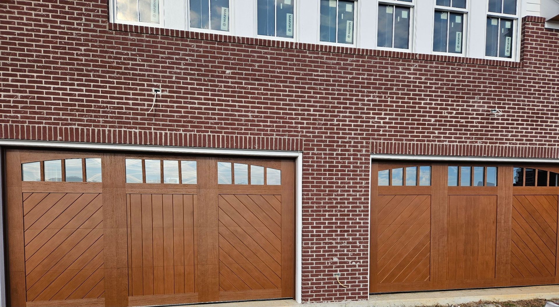 A row of wooden garage doors on a brick building