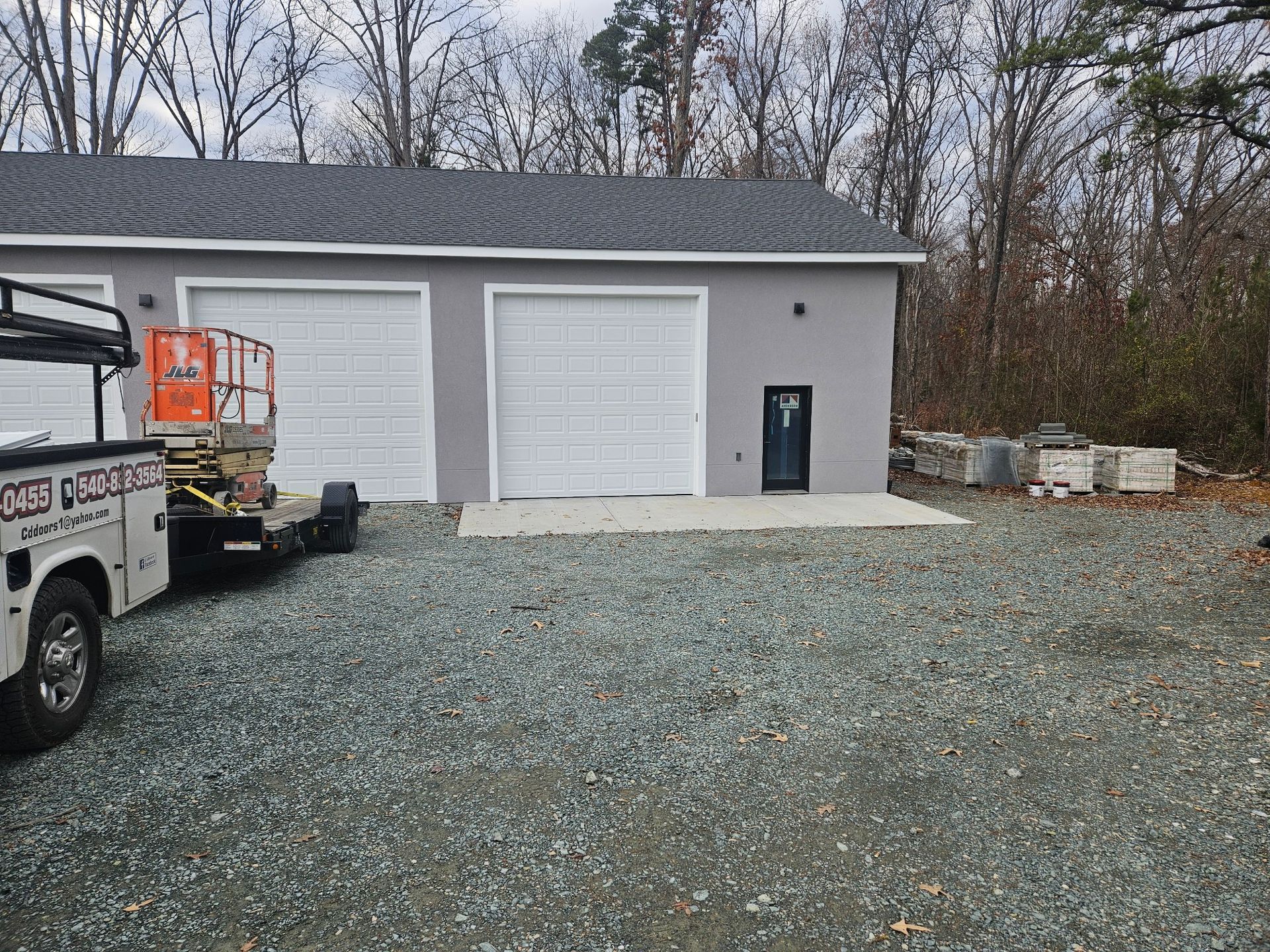 A white truck is parked in front of a garage.