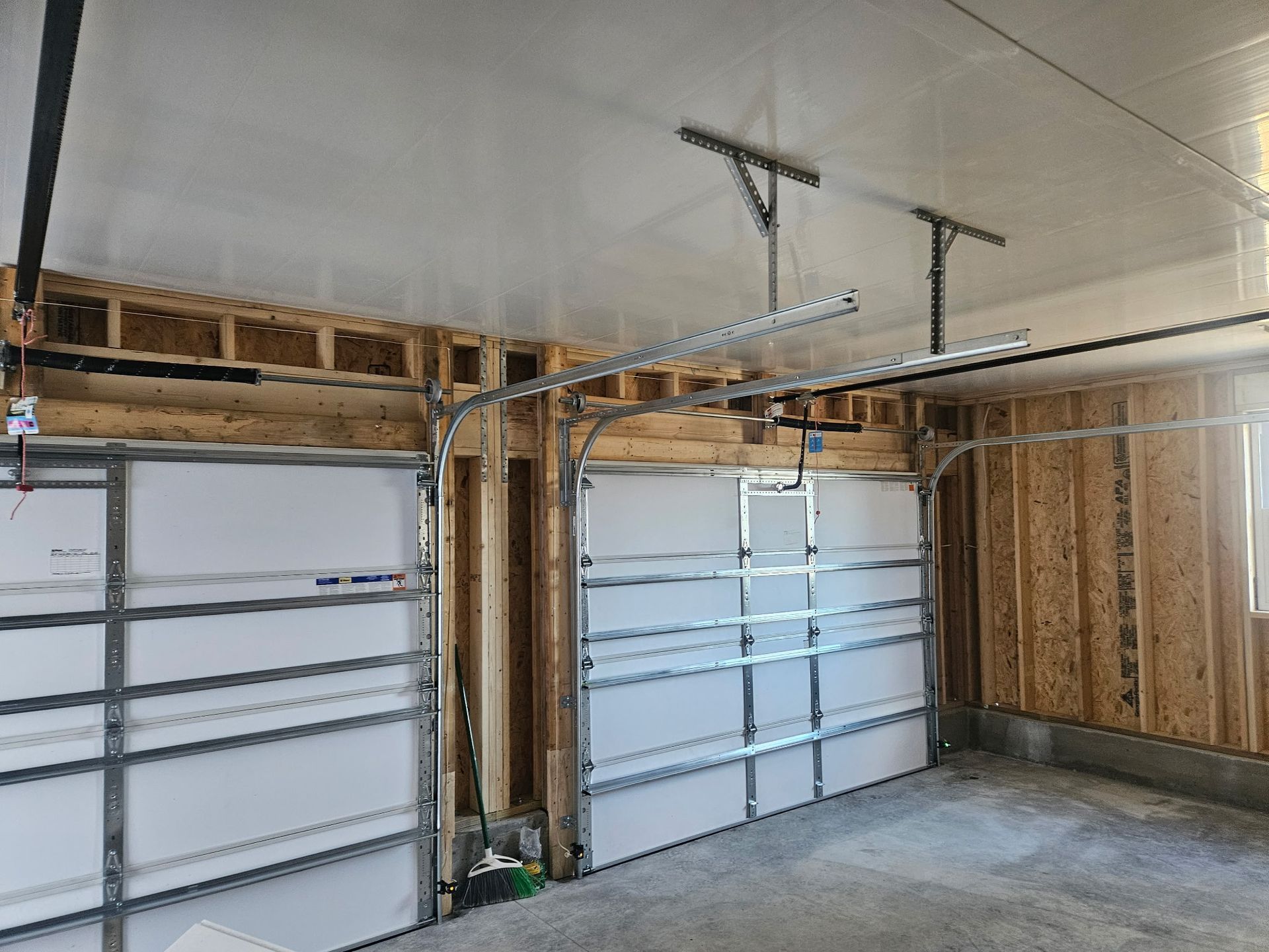 A garage with two garage doors and a ceiling.