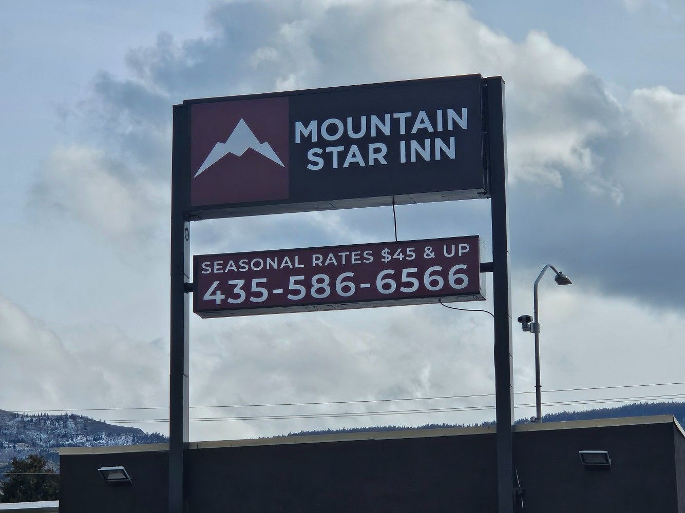 Sign for Mountain Star Inn with seasonal rates and phone number.