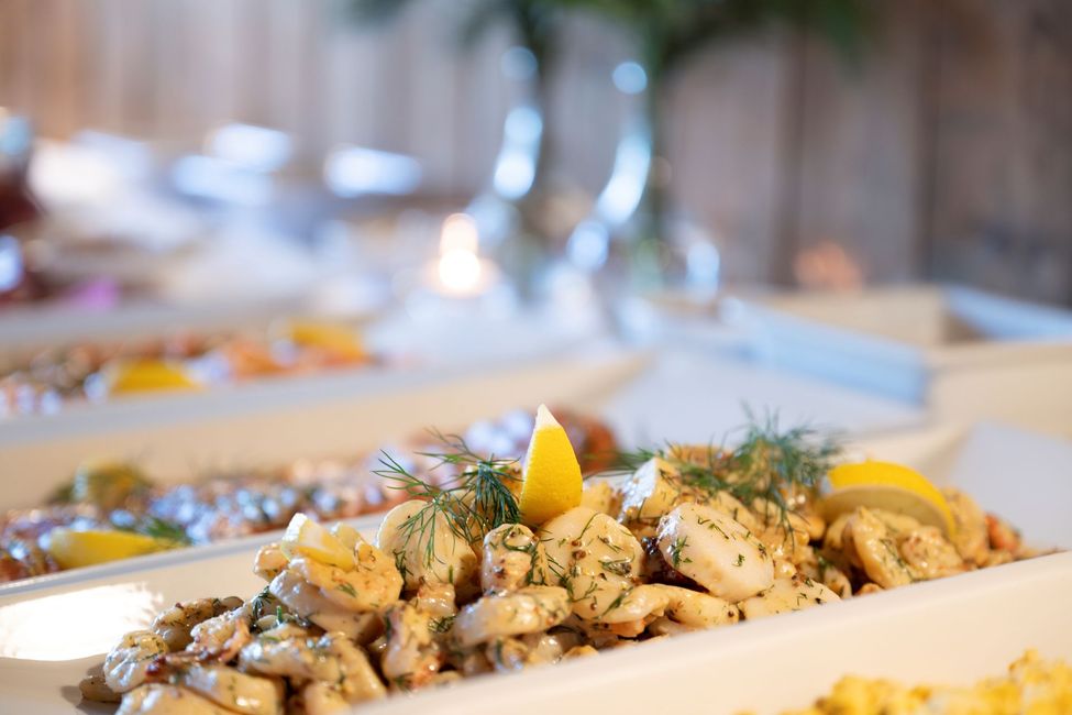 Buffébord med sjømat, sitronbåter og dill.