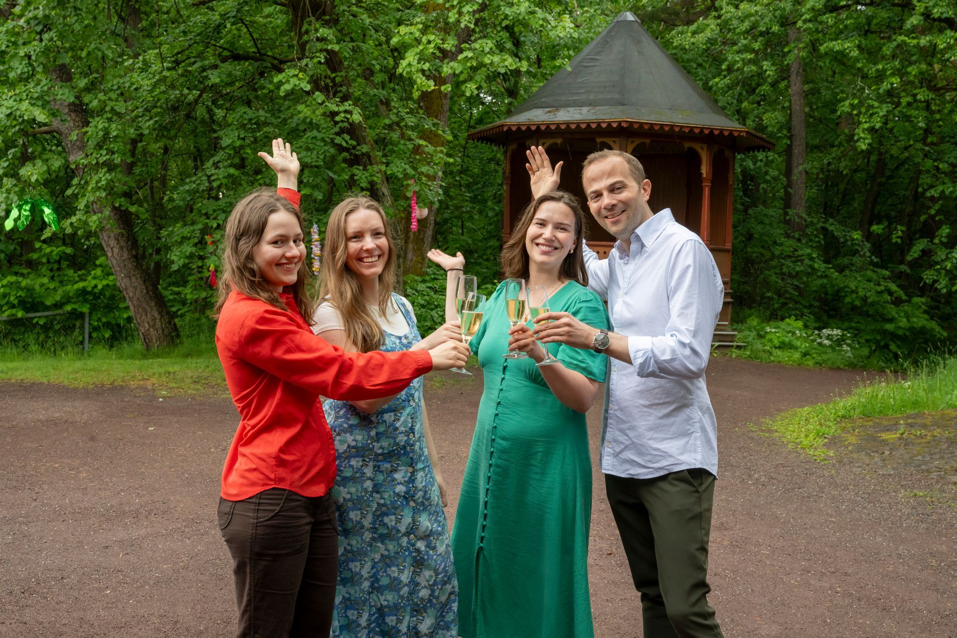 Fire glade gjester skåler på sommerfesten på Sæterhytten
