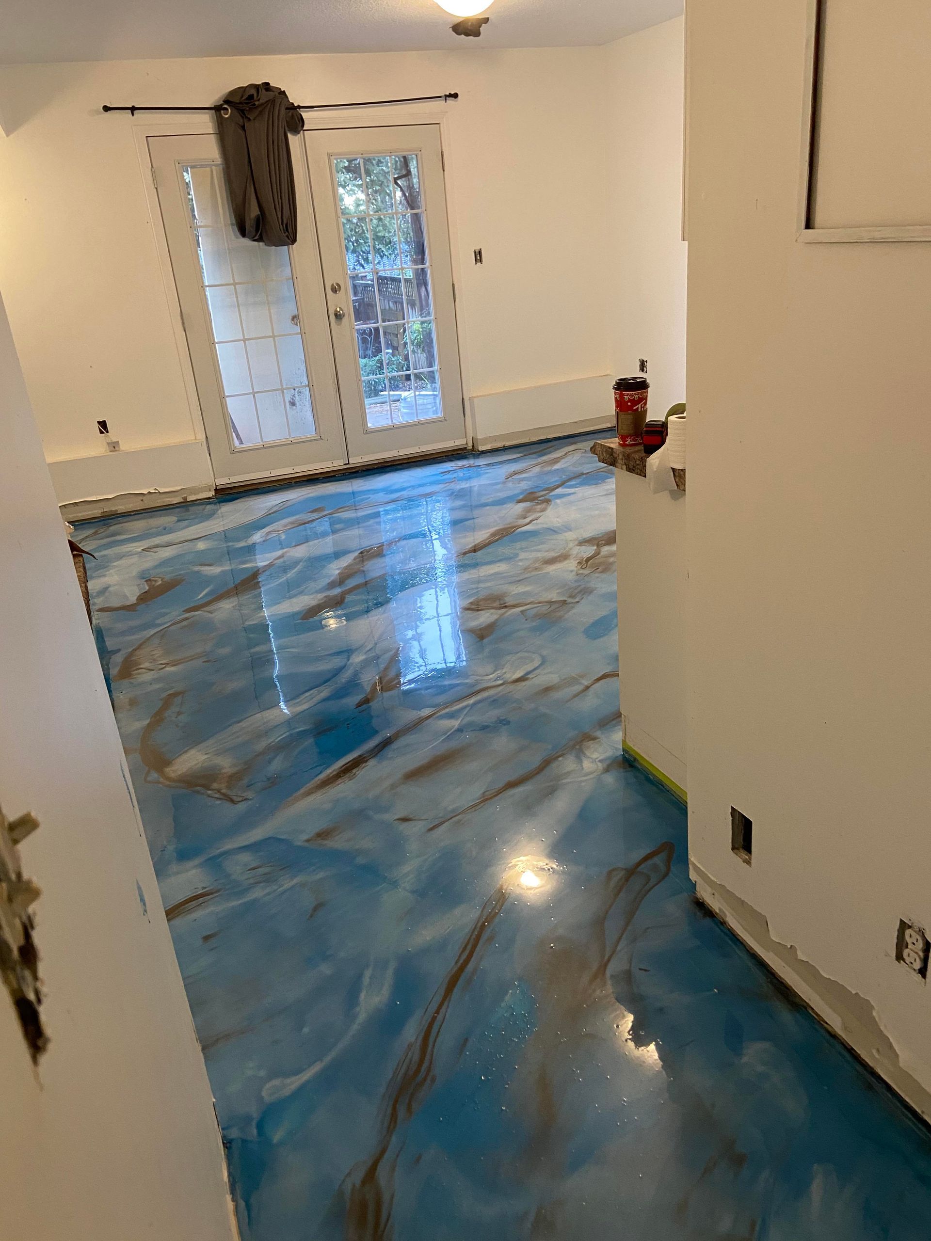 Worker carefully installing vinyl floor covering in a room, ensuring a smooth and precise fit.