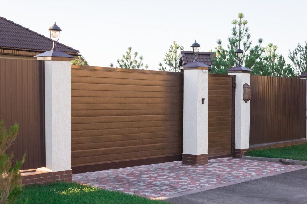 Brown Wooden Gate and Fence With White Pillars — Trade Fencing Supplies in Moolap, VIC