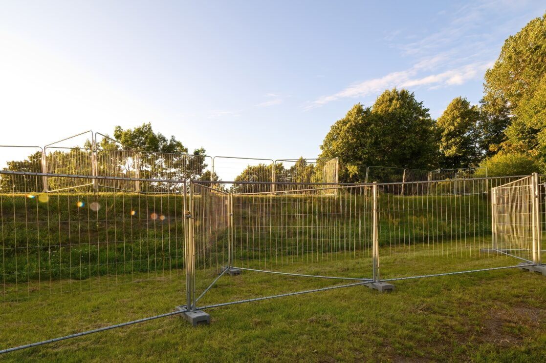 Temporary Metal Fencing on Green Grass, Trees and Sky in the Background — Trade Fencing Supplies in Surf Coast, VIC