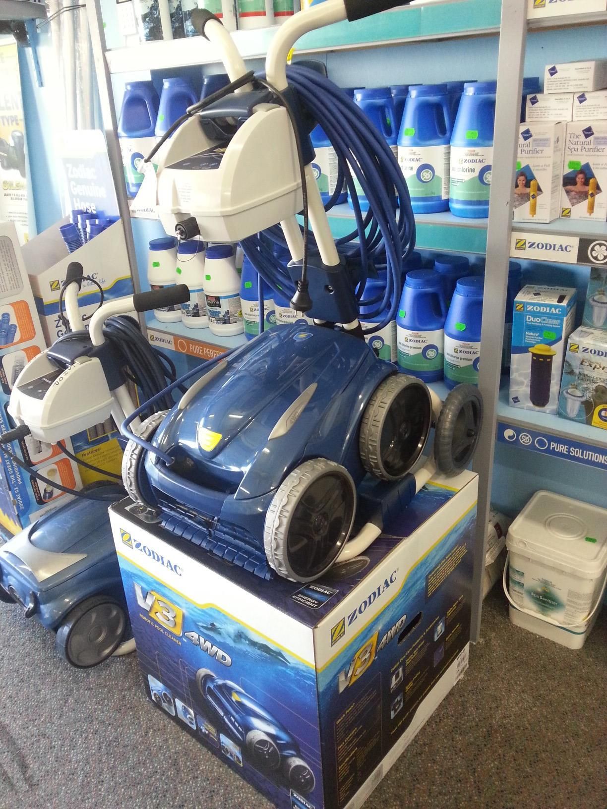A Man is Cleaning a Swimming Pool With a Robotic Vacuum Cleaner — Cessnock Pool Shop in Cessnock, NSW