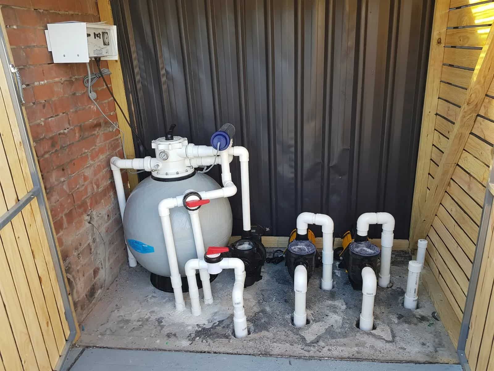 A Swimming Pool Filter is Sitting in a Shed Next to a Brick Wall — Cessnock Pool Shop in Cessnock, NSW