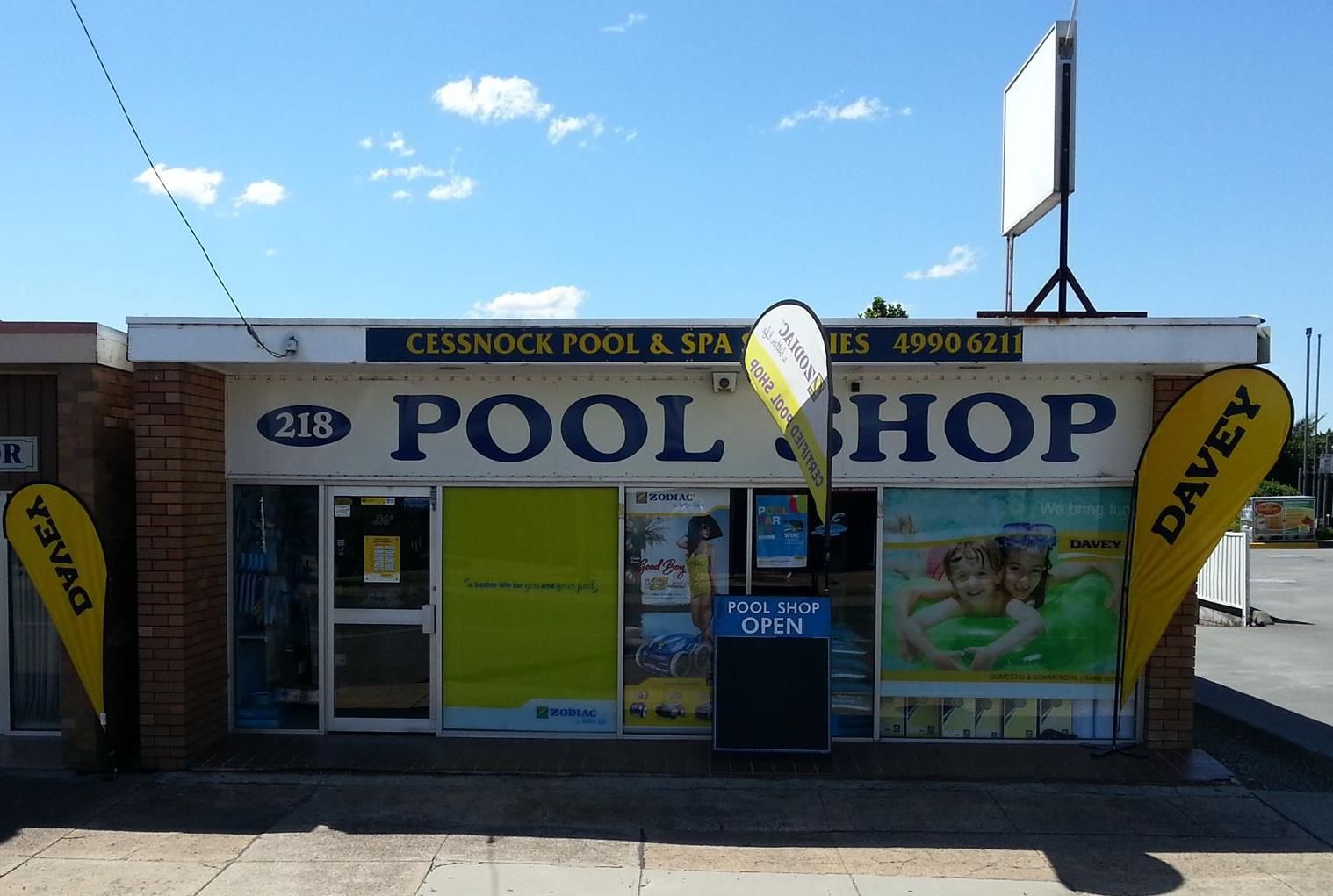 A Man is Cleaning an Empty Swimming Pool With a High Pressure Washer — Cessnock Pool Shop in Cessnock, NSW