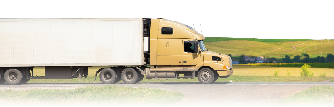 A reefer truck with a yellow cab driving on the highway.