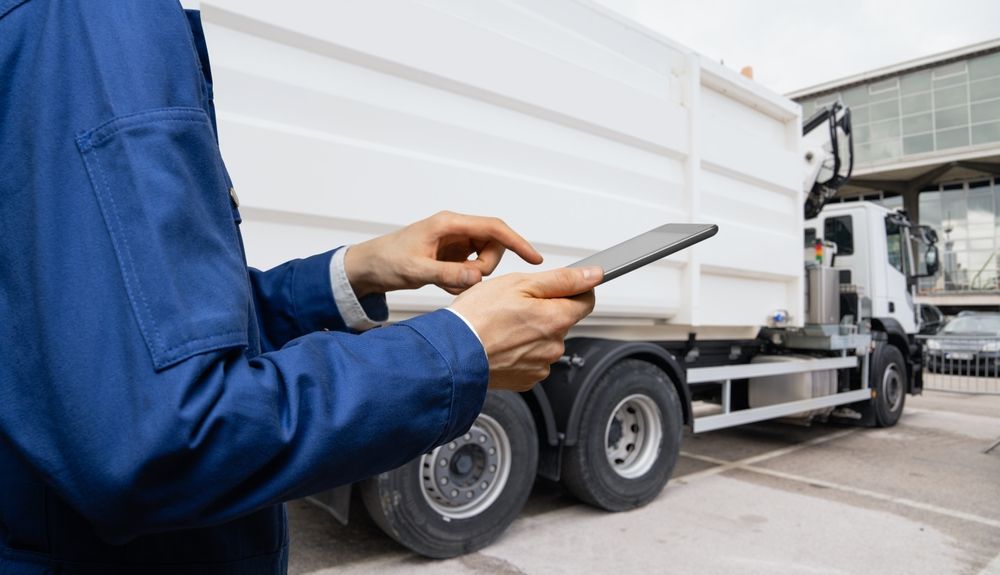Manager with a digital tablet next to a frozen carrier truck.