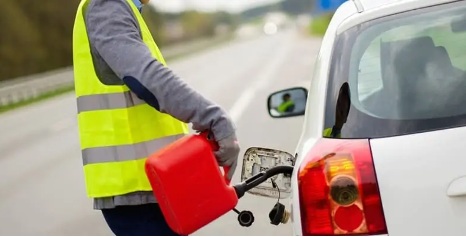 A roadside specialist delivering fuel to a customer during an emergency roadside event.