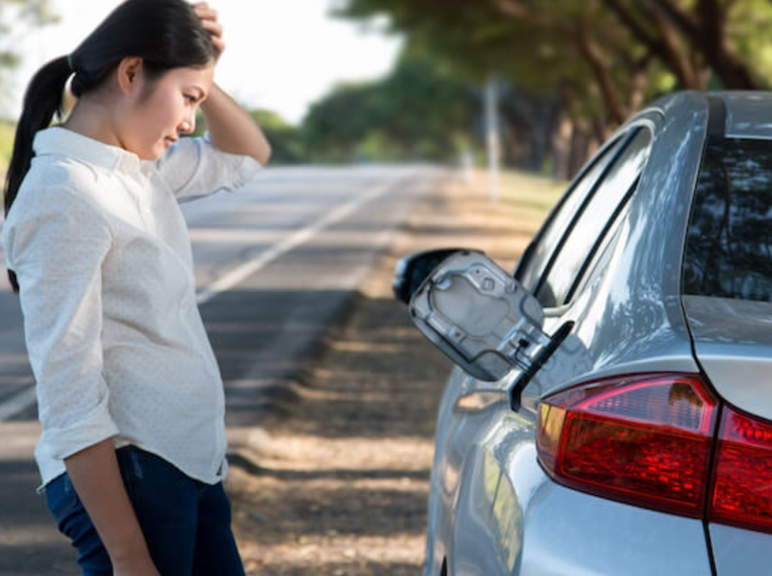 A woman who has ran out of gas from her vehicle and needs fuel delivery service.