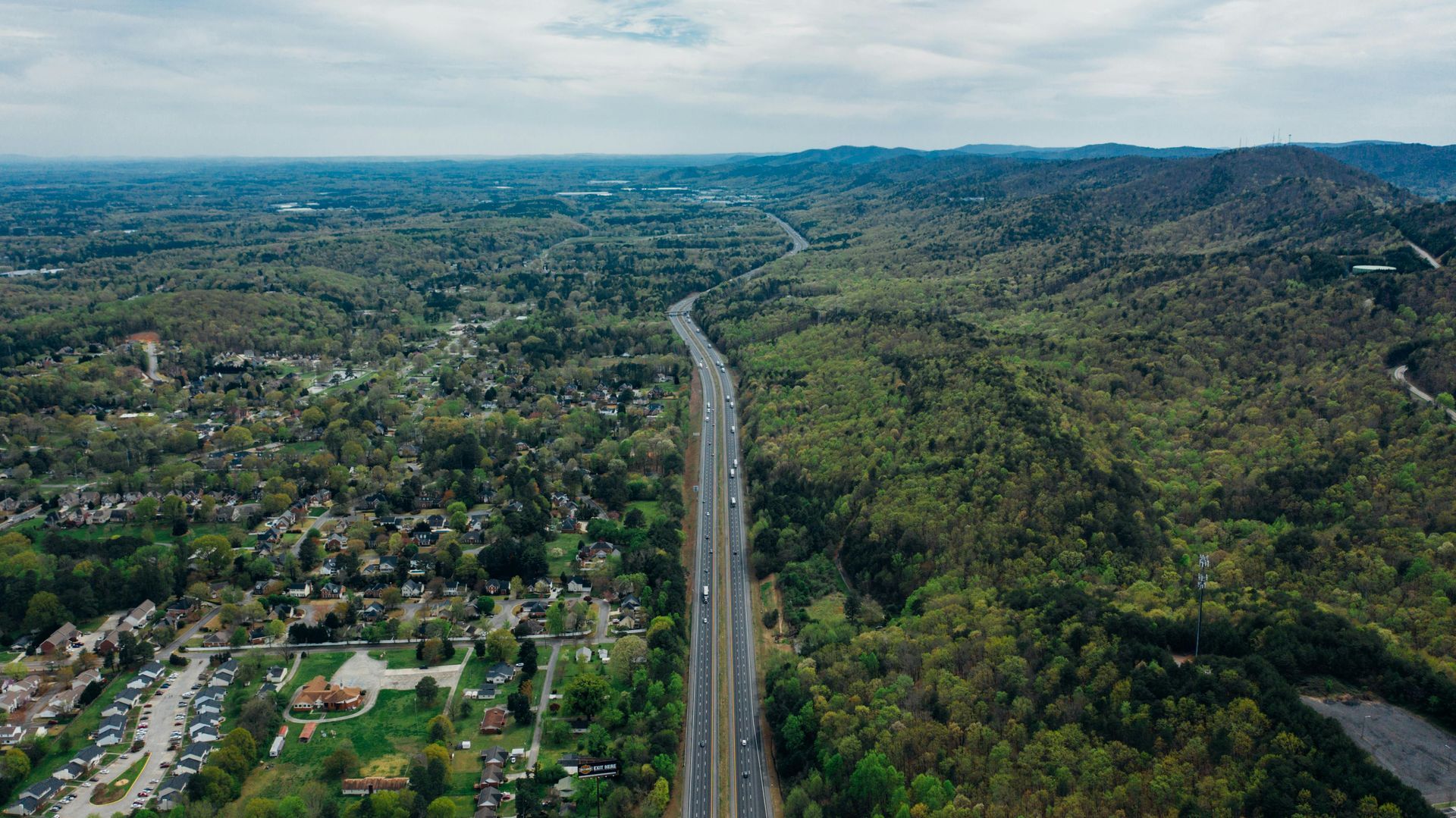 A beautiful scenery with a top-down eye view of a road with cars traveling down it.