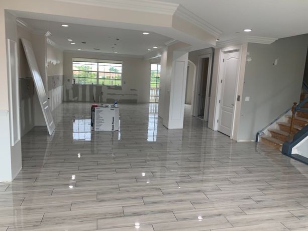 Large space for living and entertaining renovated with brand new polished tile floors that have a gray wood-look design located in Destin, Florida