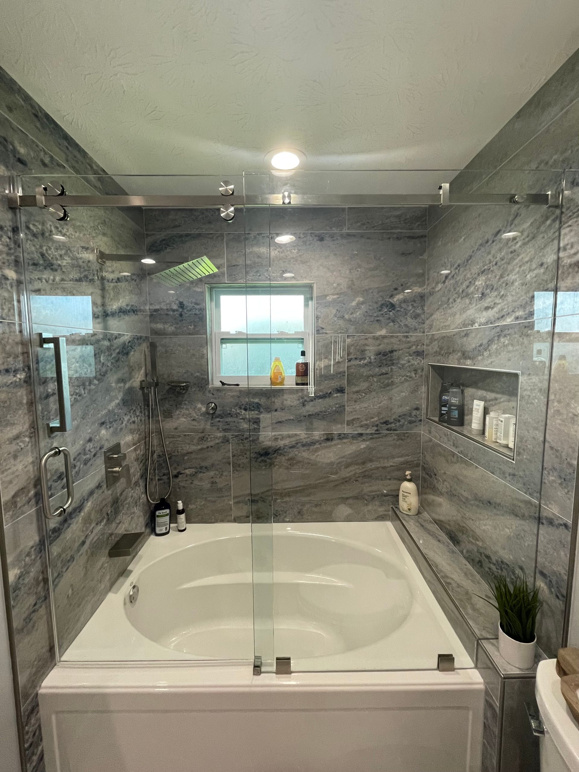 Bathroom remodel in Navarre, Florida with barn door mirrors, inset shelving, and custom makeup vanity