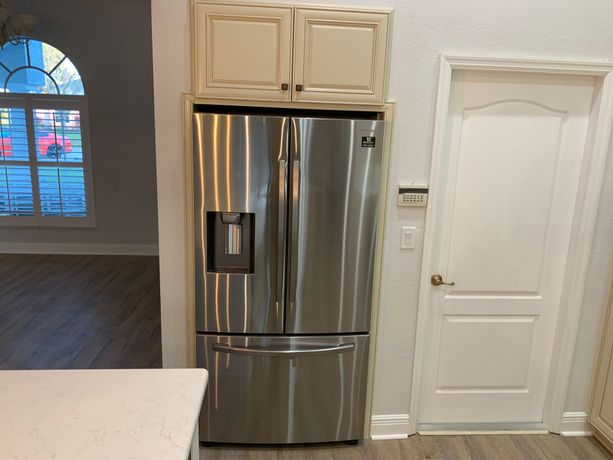 A stainless steel refrigerator is sitting in a kitchen next to a door in Myrtle Beach, South Carolina.