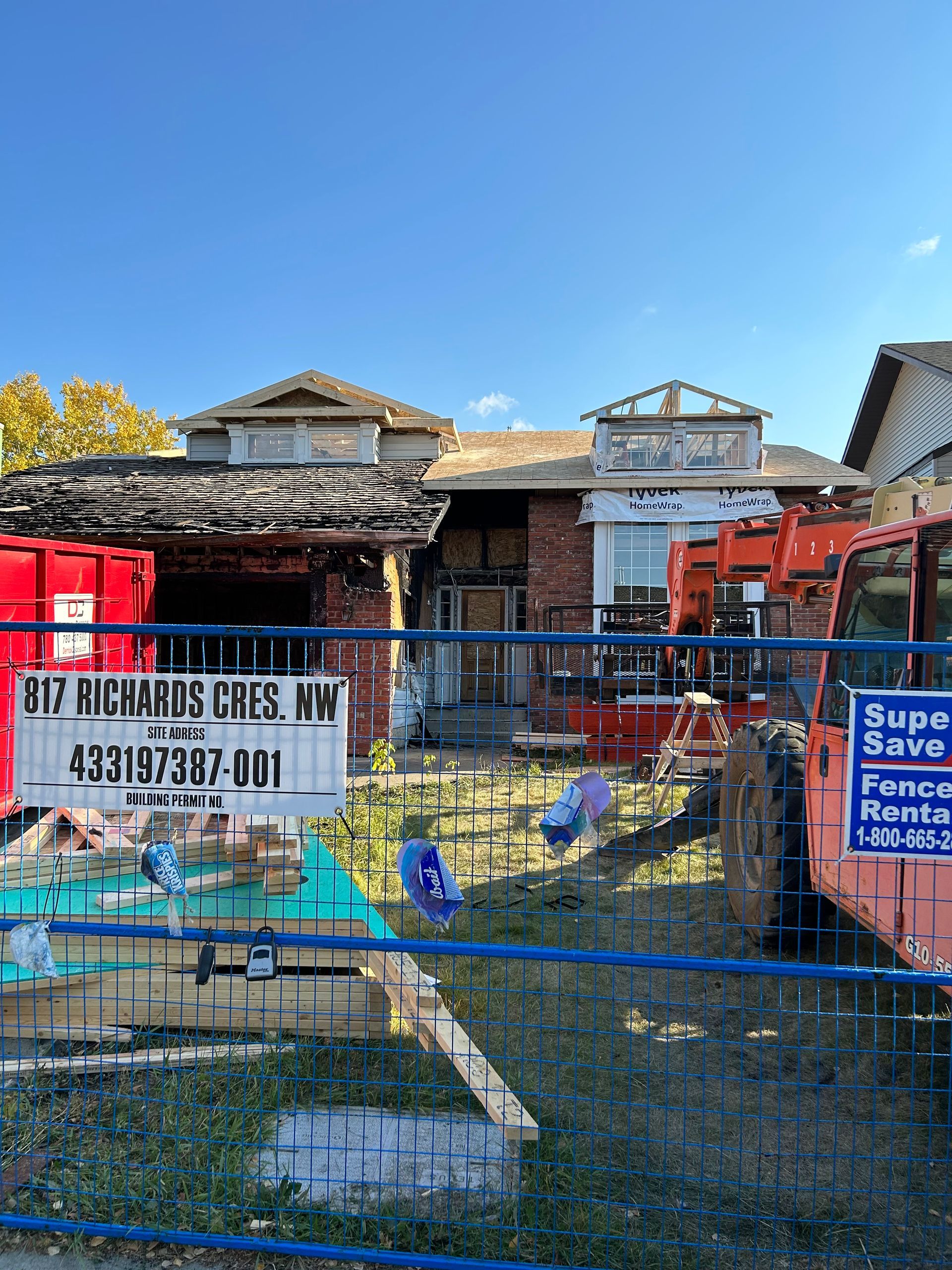 A red truck is parked in front of a house reno project