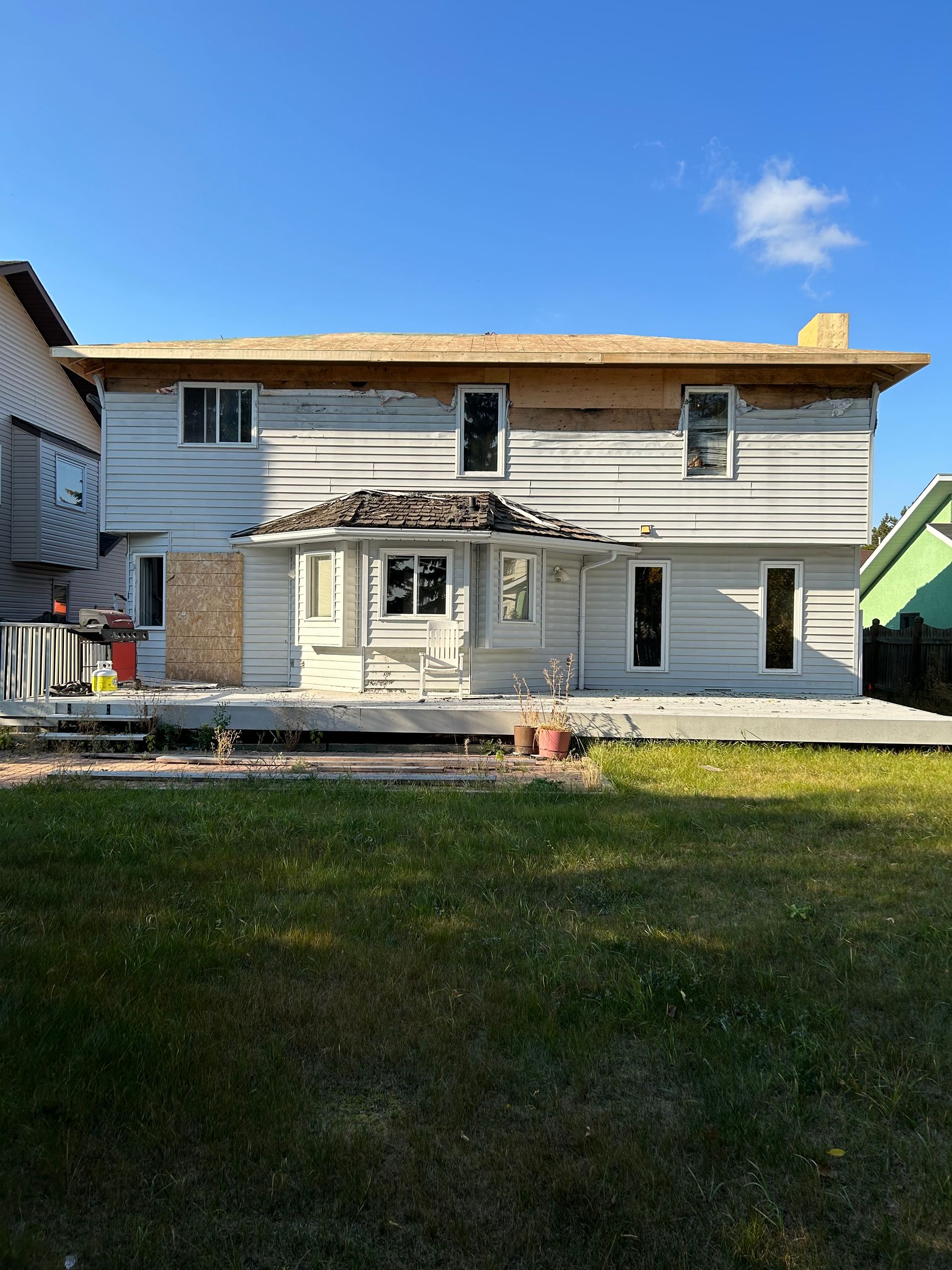 A large white house with a wooden roof - interim reno project photo