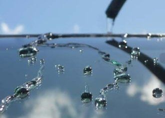 A close up of a car windshield with water drops on it