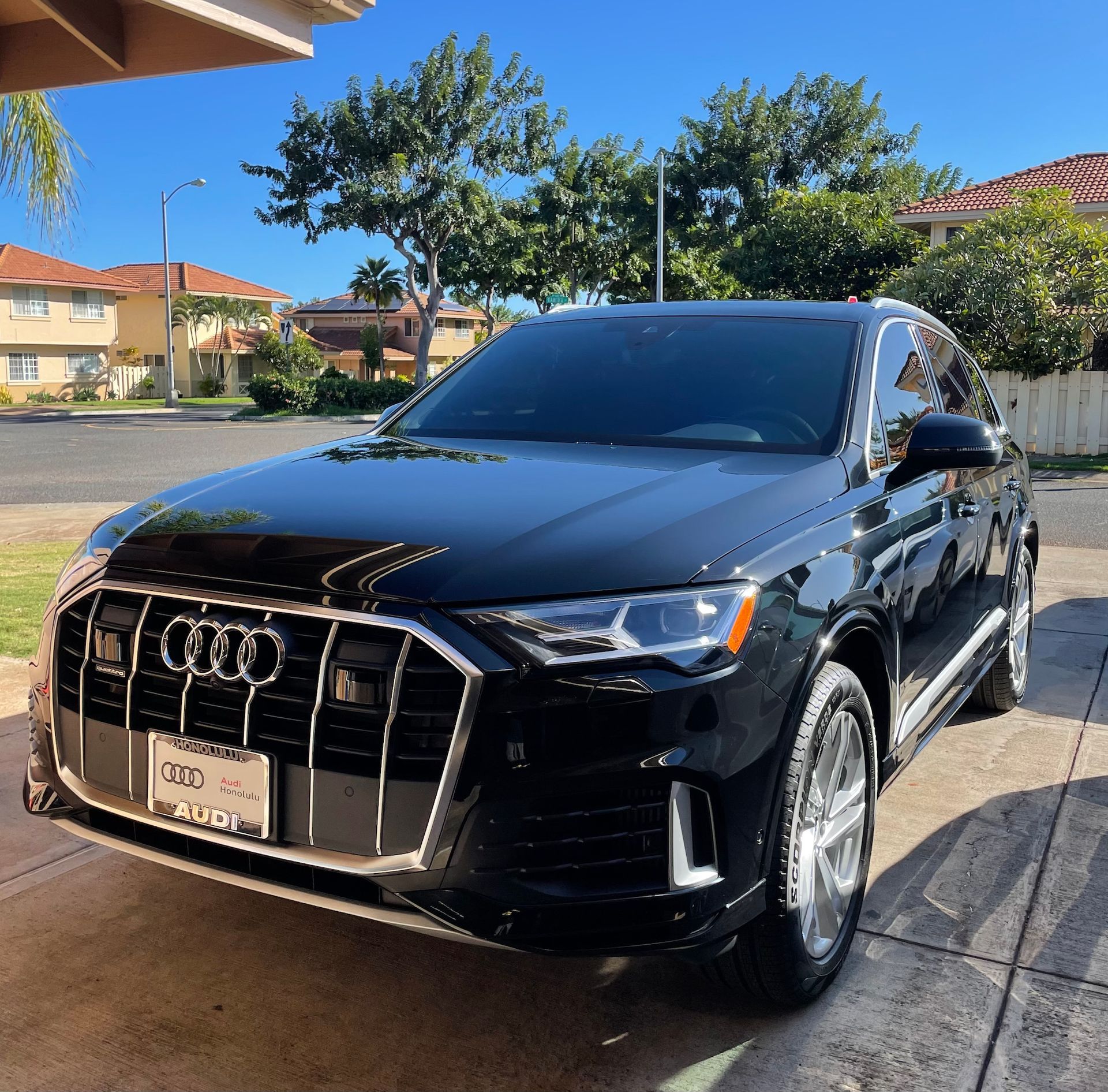 A black audi is parked on the side of the road