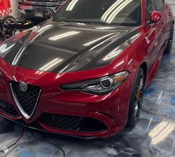 A close up of a red car 's headlight and hood