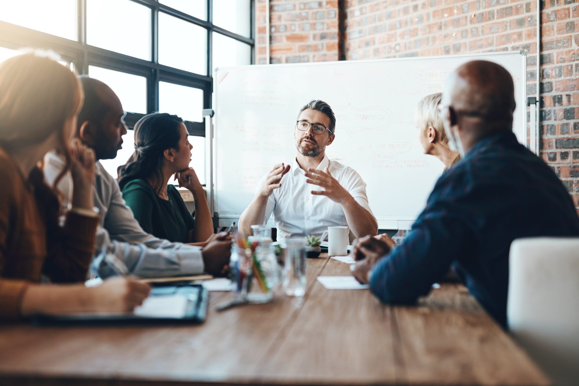 A group of people are sitting around a table having a meeting.