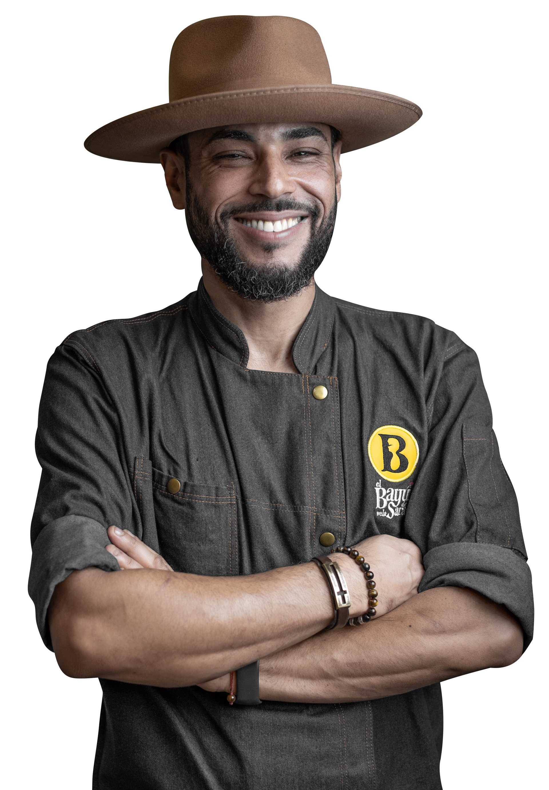 chef iram wearing a hat and a chef 's coat is smiling with his arms crossed .
